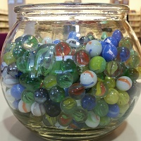 Photo of a glass fishbowl filled with marbles