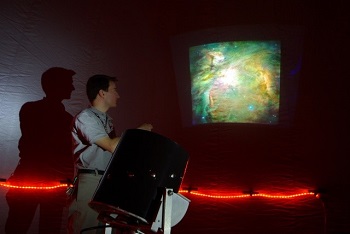 Photo of a teacher showing students images of the night sky