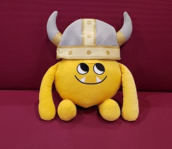 Photo of a yellow stuffed animal monster in a Viking helmet