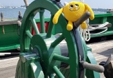 Yellow stuffed book monster at the wheel of a boat