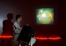 Photo of a teacher showing students images of the night sky