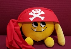 Photo of a yellow stuffed animal monster in a pirate hat