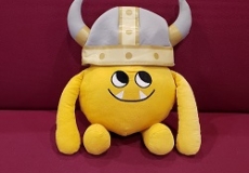 Photo of a yellow stuffed animal monster in a Viking helmet